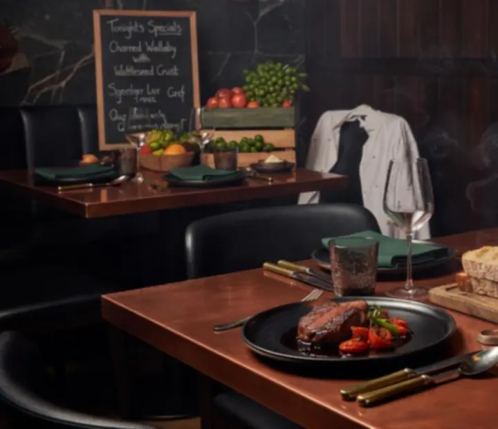 Chef's after dark dining spread beside a softly lit poker table
