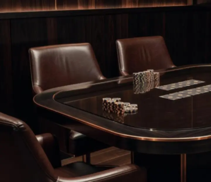 Private poker table setting with cards, chips, and candlelit glasses in a dark Australian card room.